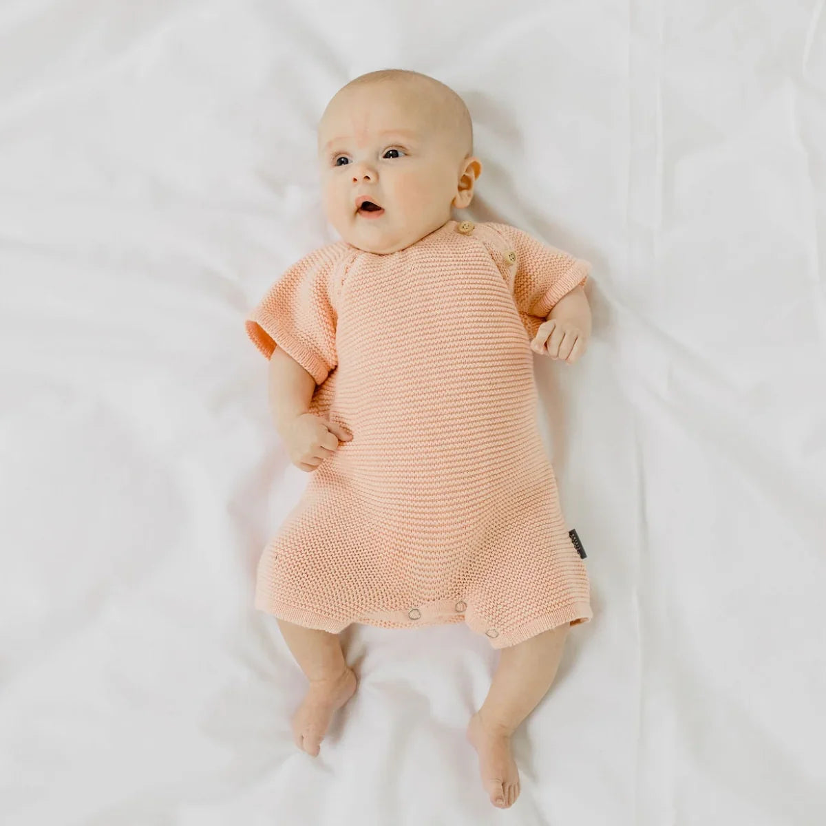 Charlie Pink Knit Romper in pink has a stud opening for easy dressing.