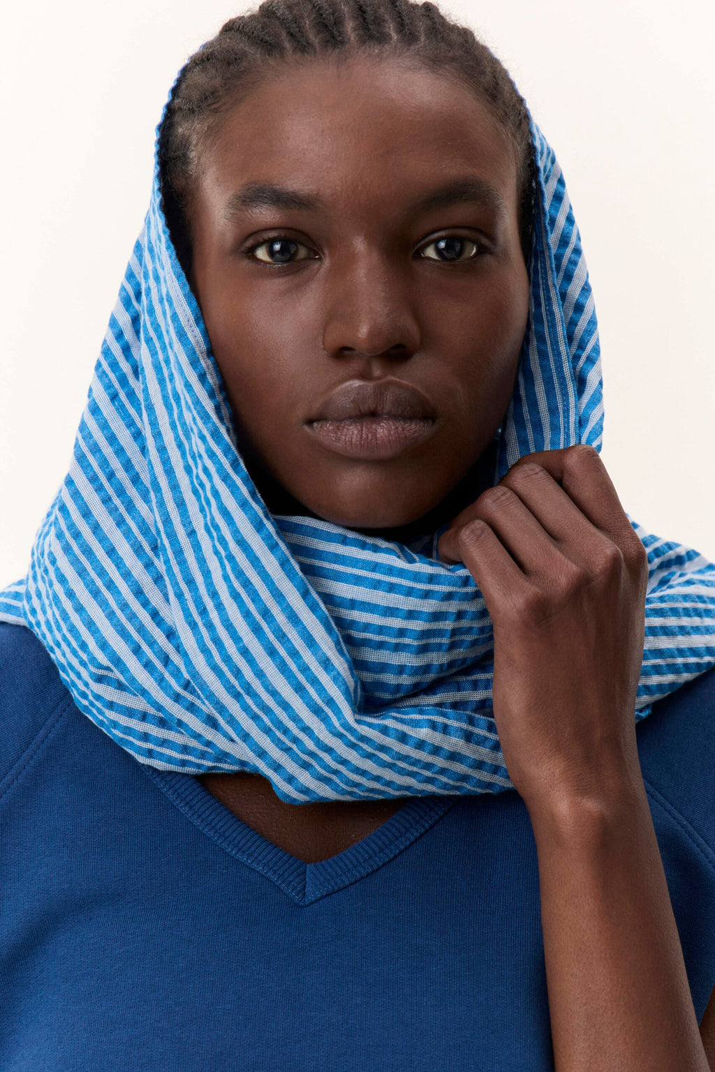 Emee Mix Scarf – lightweight striped scarf in organic cotton, shown in blue, green, and red variants, draped softly over a natural fabric surface.